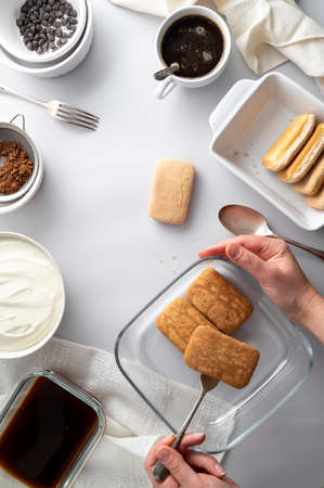 Tiramisu cake step by step recipe. Ingredients for cooking tiramisu dessert, grey background, vertical image. Top view.の写真素材