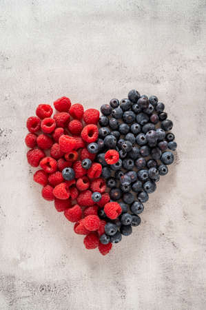Raspberry and blueberry heart. Healthy food, nutrition and detox concept. Top viewの写真素材