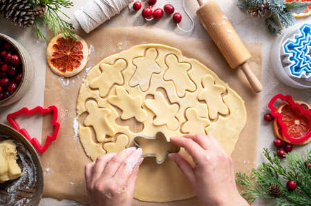 Cooking Christmas cookies. Female hands with christmas tree cookie cutter. Step by step recipe. Top view.の写真素材