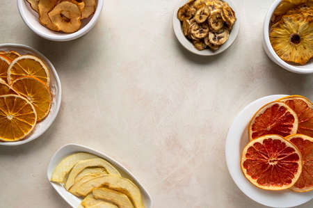 Homemade organic dried fruit slices in plates, top view. Dried orange, grapefruit, pineappleの写真素材