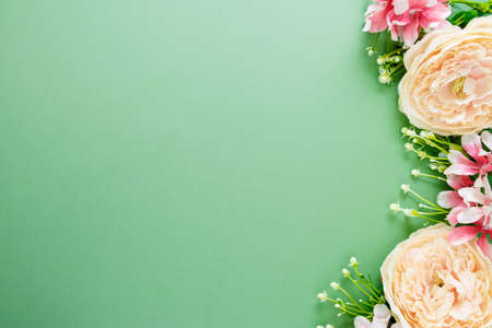 Spring background with flower composition on green board. Festive frame or border. Top view with copy space for text.の写真素材