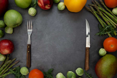 Healthy foods or diet concept. Different fruits and vegetables arround. Mango, apples, asparagus, bell pepper, tomatoes. Flat lay, copy space.の写真素材