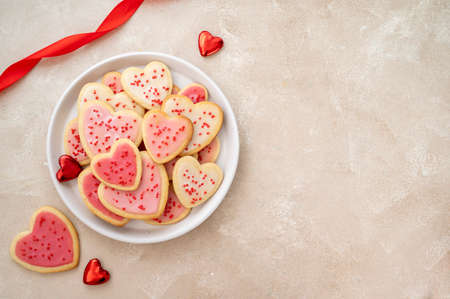Heart cookies. Homemade butter cookies with pink glaze and sprinkles. Top view
