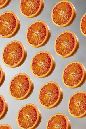 Bloody orange pattern on gray background. Abstract citrus fruit composition