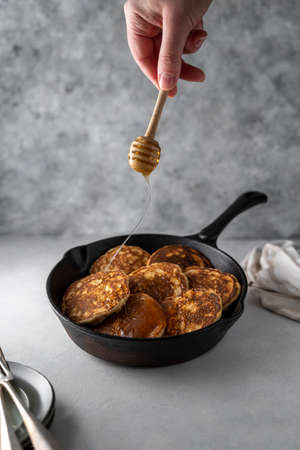 Pancakes in frying skillet pan with honey, breakfast, food photo