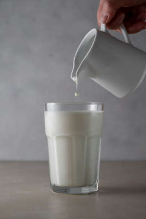 Milk poured into glass. Dairy product conceptの写真素材