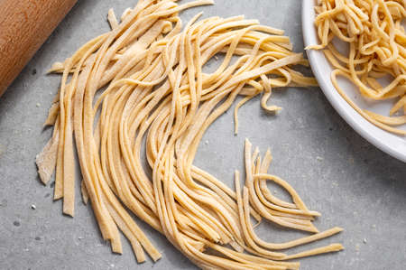 Raw homemade noodles, egg noodles. Home, healthy cooking concept.