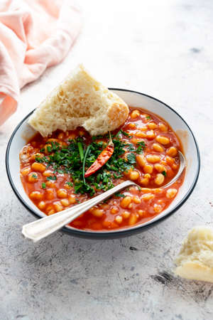 Red beans with tomato sauce in a bowl, bright backgroundの写真素材