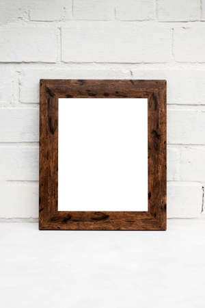 Portrait Wooden frame Mockup on white brick wall. PModern, minimal frame. Empty frame with copy...