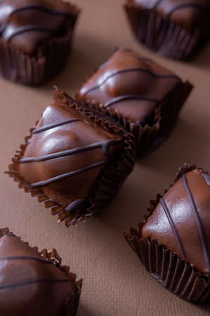 Chocolate mini cakes on brown background.
