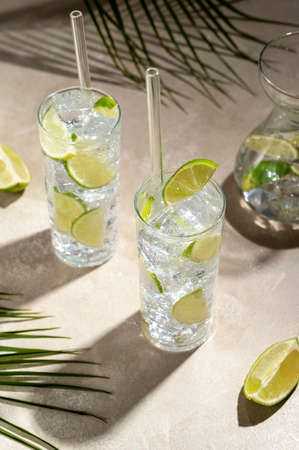 Refreshing lemonade drink with ice, lemon sun light and shadow