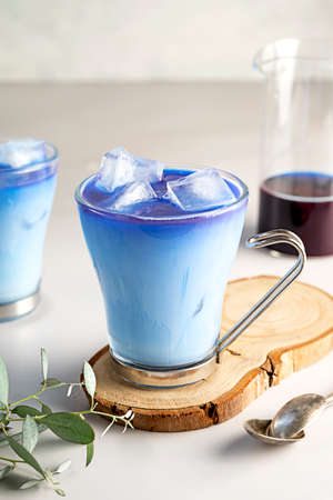 Ice latte with blue butterfly pea. Refreshing blue matcha latte in a glass cups with ice cubes. Summer blue drinkの写真素材