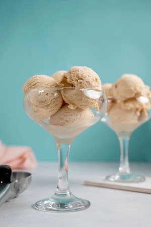 Ice cream balls scoops in glass cups on blue background. Delicious summer treats