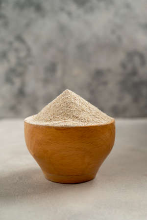 Buckwheat flour in wooden bowl, buckwheat grain, gluten free flour concept. Healthy foods
