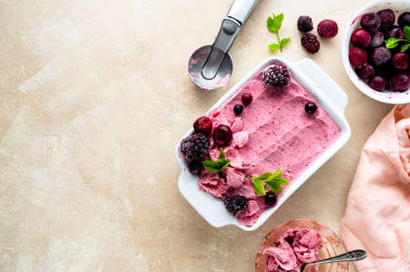 Homemade fruit, pink sorbet with banana and berry ice cream summer refreshing treat, copy space for textの写真素材
