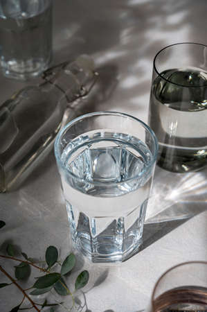Glasses with water, abstract summer shadows on background. Drinking water concept clean waterの写真素材