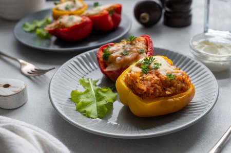 Stuffed bell peppers with rice, meat and vegetables grey neutral background. Homemade healthy foods