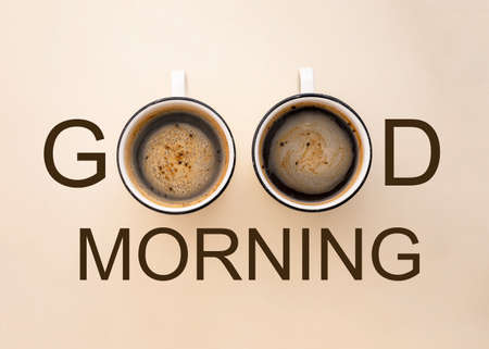 Good Morning inscription made from two cups of coffee, neutral warm background. Positive lettering