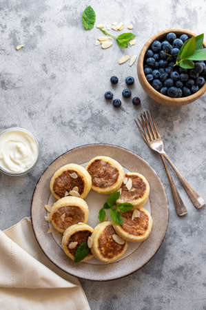 Cottage cheese fritters, ricotta pancakes with sour creamand bleberries. Healthy food. Top view