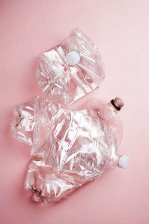 Empty used plastic bottle isolated on pink background, flatlay. Abstract recycling conceptの写真素材