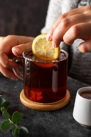 Black tea in glass cup, morning hot drink with lemon and honey.
