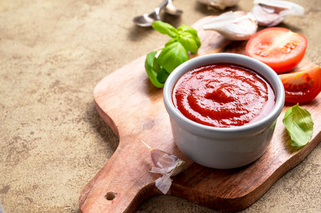 Tomato pizza sauce in bowl. Homemade sauce for cooking pizza with fresh basilの写真素材