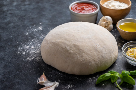 Raw dough with ingredients for cooking pizza. Sourdough pizza, baking at homeの写真素材