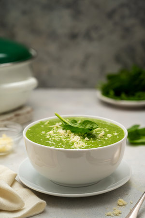 Spinach soup. Green creamy, vegan creamy soup on bright backgroundの写真素材
