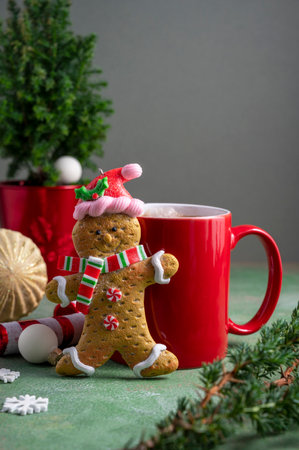 Gingerbread man and red cup with hot chocolate drink and winter ornaments. Christmas abstract background.の写真素材