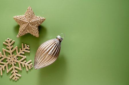 Christmas golden baubles with fir branches, decorations, golden baubles on green background. Winter abstract compositionの写真素材