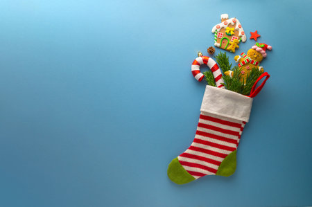 Christmas greeting with christmas gift sock, fir tree branches, cookies, Christmas candy cane on...