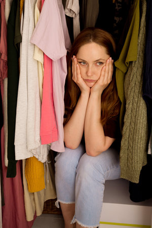 Woman cant decide what to wear, closet with too many clothing. Overburdened with clothesの写真素材
