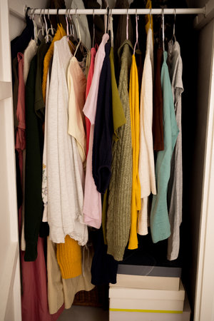 Women clothing on hangers in a built-in wall cabinetの写真素材