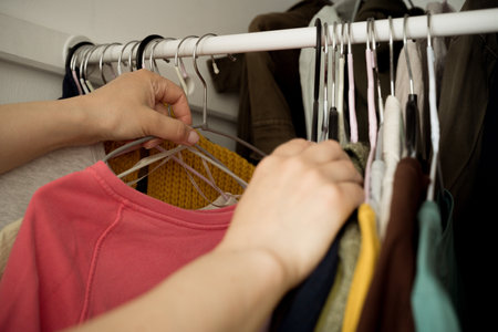 Woman choosing clothes from her closetの写真素材