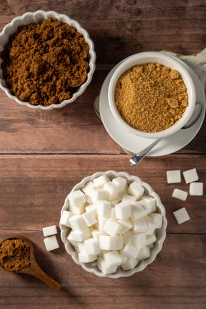 Light brown, dark brown and white sugar cubes in bowls. Different type of sugarの写真素材