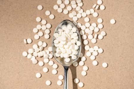 Sugar substitute, sweetener pills in a spoon, top view. Food supplement. Diabetic, over weight, health conceptの写真素材