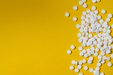 Sugar substitute, sweetener pills over yellow background. Food supplement. Diabetic, over weight, health concept.の写真素材