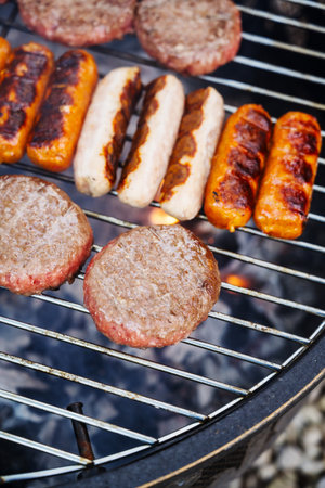 Cooking burgers and hot dogs on bbq grill, outdoorの写真素材
