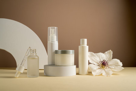 Blank cosmetics jars and bottles with white flower. Beauty concept, neutral backgroundの写真素材