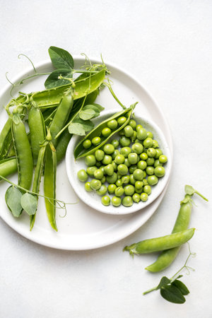 Fresh green peas beans in a white plate, copy space