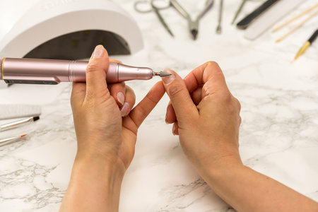 Nail drill bit closeup, woman making her gel nail manicure at homeの写真素材