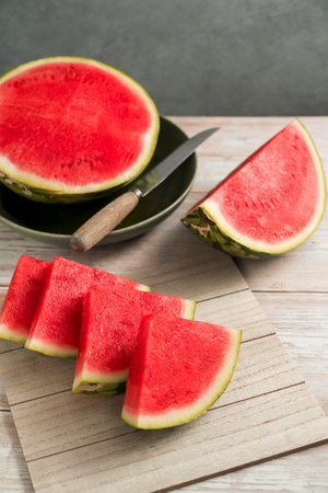 Slices of fresh watermelon on bright rustic wooden tableの写真素材