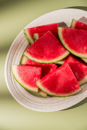 Slices of fresh watermelon in a plate, green backgroundの写真素材