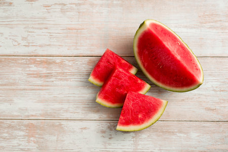 Slices of fresh watermelon on bright rustic wooden table, copy spaceの写真素材