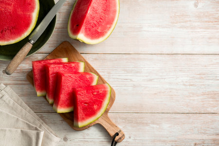 Slices of fresh watermelon on bright rustic wooden table. Copy spaceの写真素材