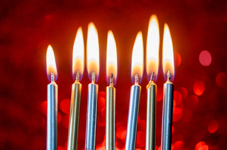 Birthday cake candles with red sparkling red background. Burning candles, celebratingの写真素材