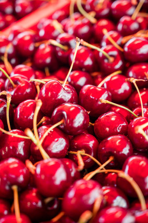 Fresh red cherries closeup, summer fruits, outdoor market stallの写真素材