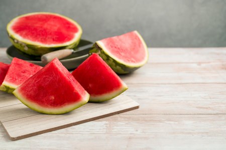 Slices of fresh watermelon on bright rustic wooden table, copy spaceの写真素材