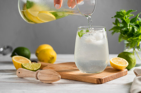 Pouring homemade lemonade drink made from lemons, limes and fresh mint.の写真素材