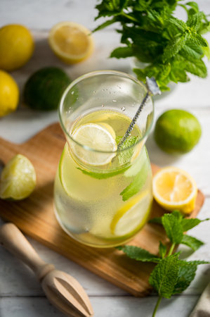 A glass jug with lemonade with lemons, limes and fresh mint, summer drinkの写真素材